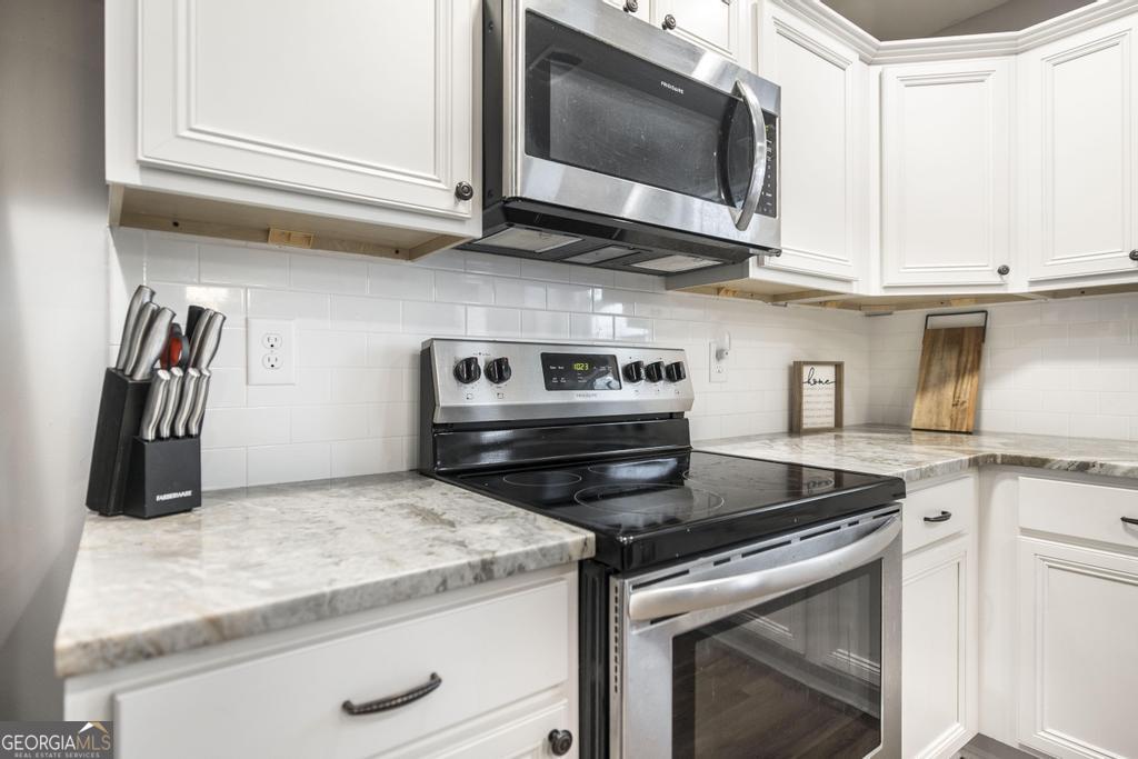 137 Sadie Heights Boulevard Perry, GA 31069 - Photo 11 of 25 a kitchen with granite countertop a stove and a microwave