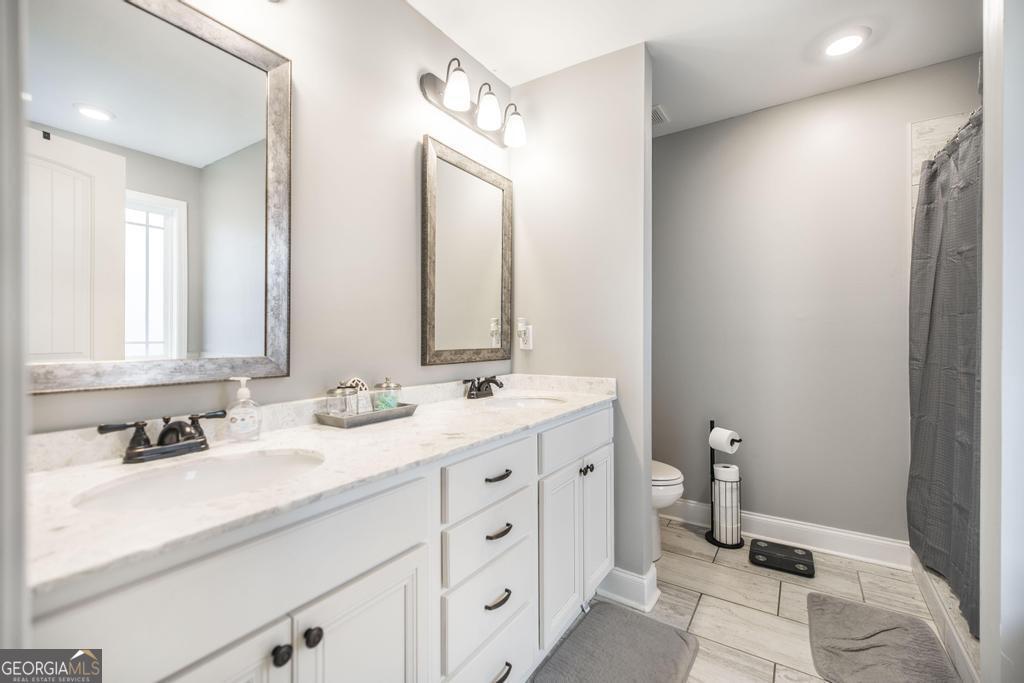 137 Sadie Heights Boulevard Perry, GA 31069 - Photo 16 of 25 a bathroom with a double vanity sink and mirror