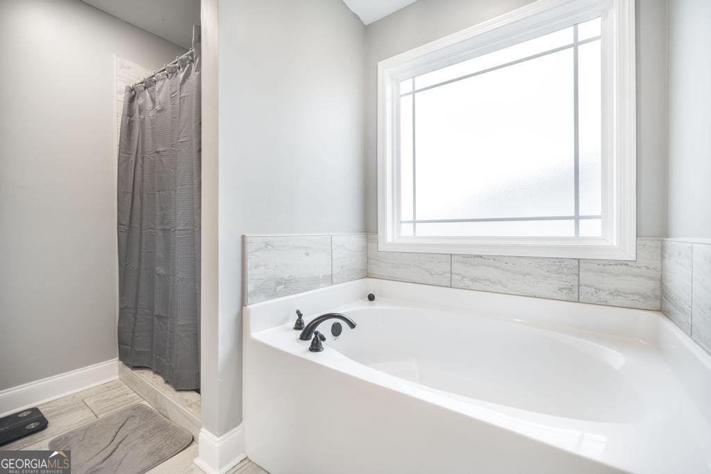 137 Sadie Heights Boulevard Perry, GA 31069 - Photo 17 of 25 a white bath tub sitting next to a window