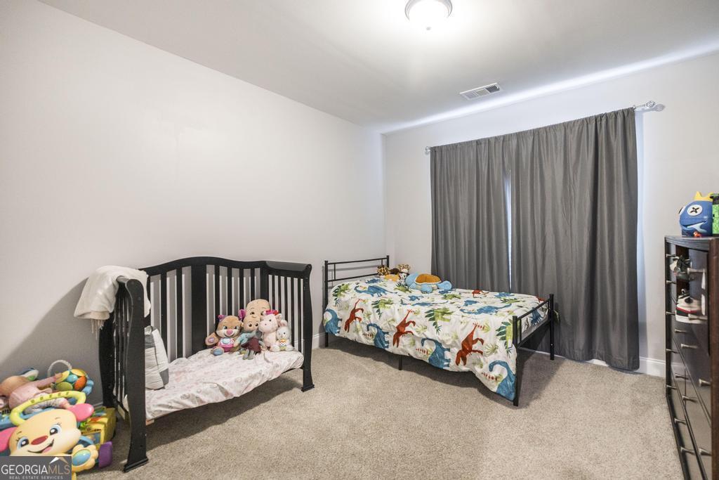137 Sadie Heights Boulevard Perry, GA 31069 - Photo 18 of 25 a bed sitting in a bedroom next to a window