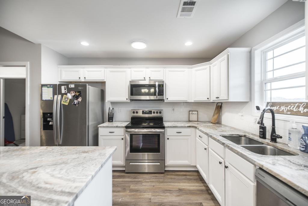 137 Sadie Heights Boulevard Perry, GA 31069 - Photo 9 of 25 a kitchen with granite countertop a stove top oven sink and refrigerator
