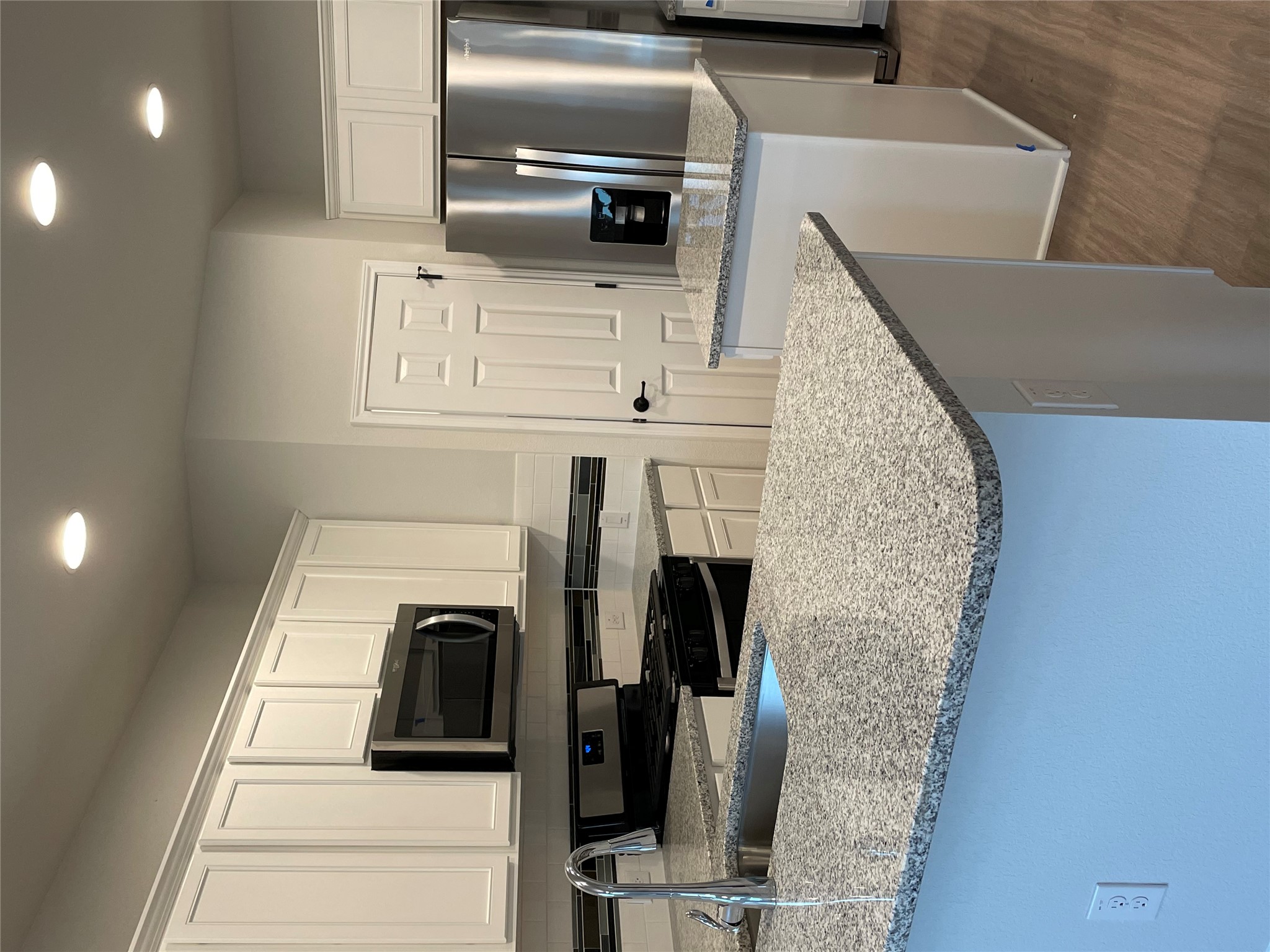 3908 Birdwatch Loop, Unit 56 Pflugerville, TX 78660 - Photo 7 of 30 a kitchen with stainless steel appliances granite countertop a sink a stove a refrigerator a microwave and cabinets