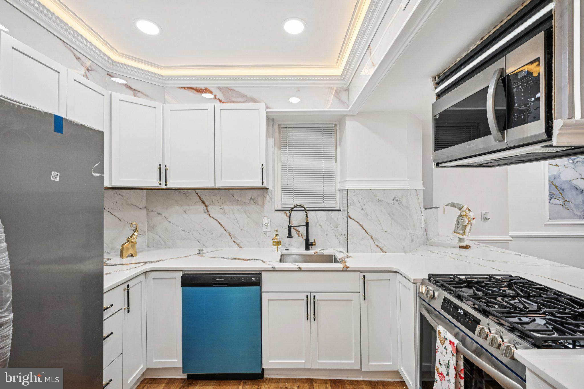 5702 Belmar Street Philadelphia, PA 19143 - Photo 8 of 29 a kitchen with a sink stove and cabinets