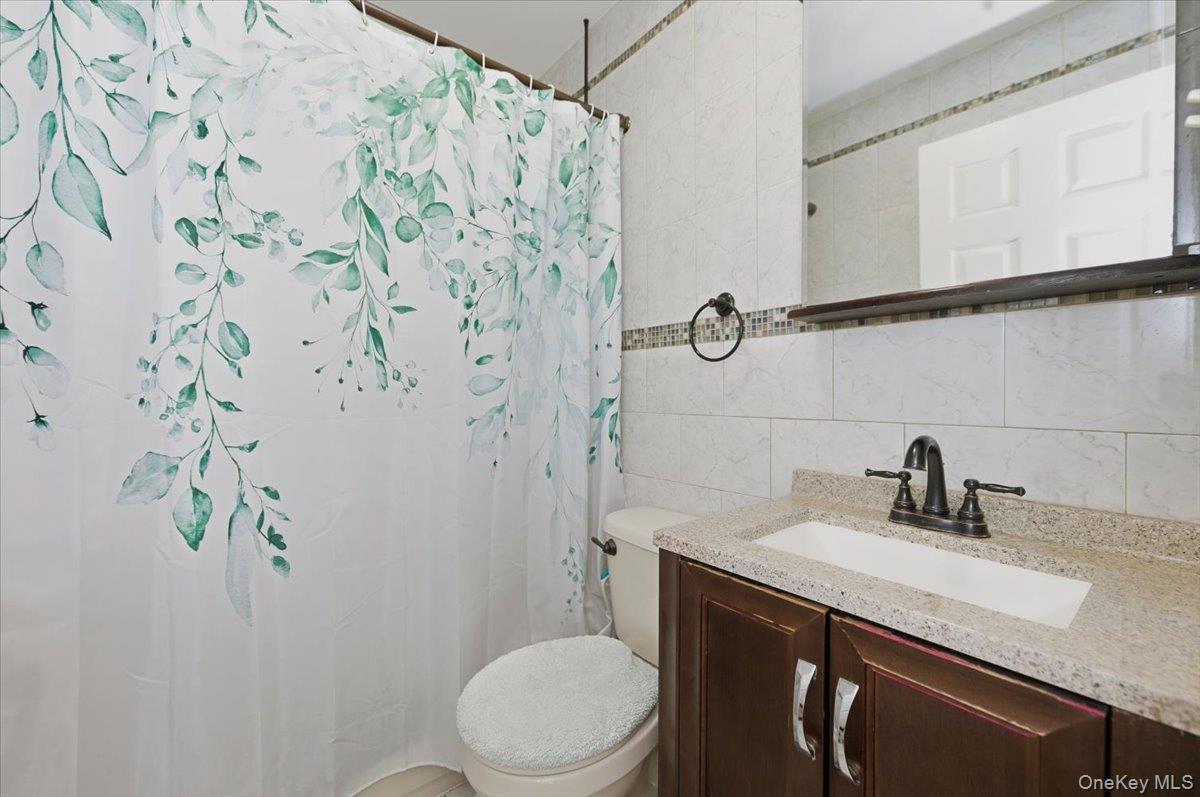 2853 Ely Avenue, Unit 3 Bronx, NY 10469 - Photo 11 of 20 a bathroom with a sink toilet and vanity