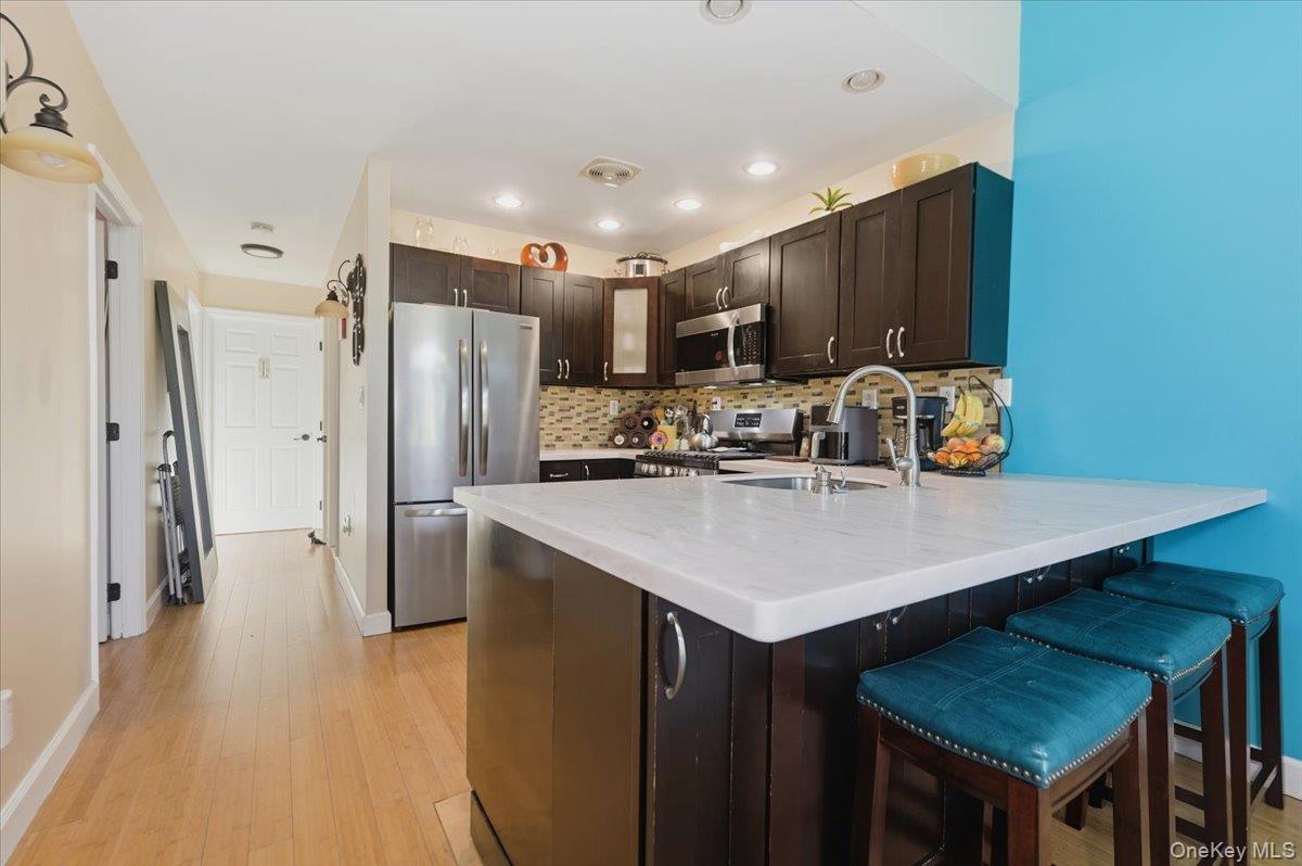 2853 Ely Avenue, Unit 3 Bronx, NY 10469 - Photo 5 of 20 a kitchen with stainless steel appliances a refrigerator a sink a stove a dining table and chairs