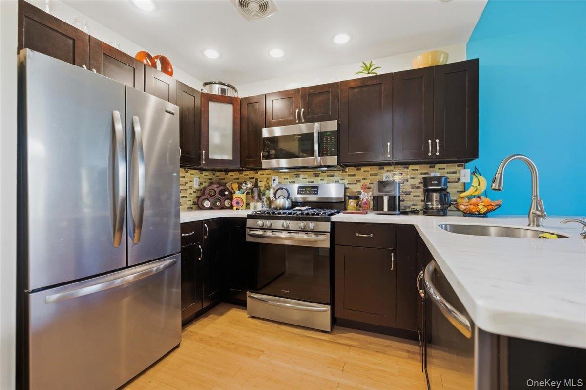 2853 Ely Avenue, Unit 3 Bronx, NY 10469 - Photo 6 of 20 a kitchen with stainless steel appliances granite countertop a refrigerator stove and sink