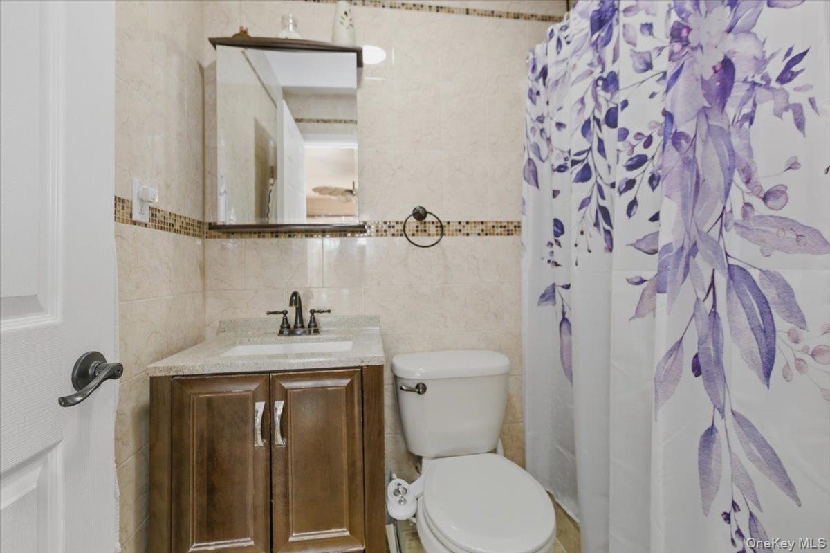 2853 Ely Avenue, Unit 3 Bronx, NY 10469 - Photo 9 of 20 a bathroom with a granite countertop sink toilet and shower
