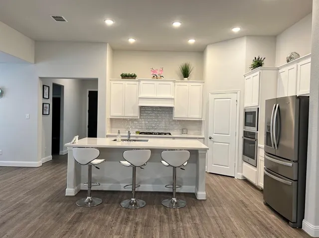 a large kitchen with a table and chairs