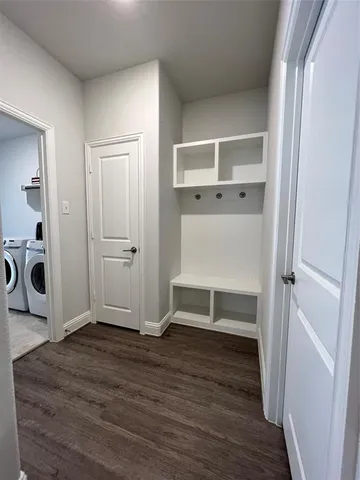 an empty room with wooden floor closet and windows