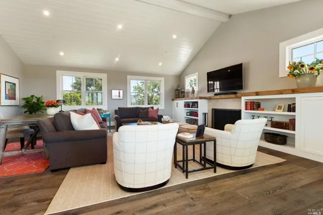 a living room with furniture a flat screen tv and a fireplace