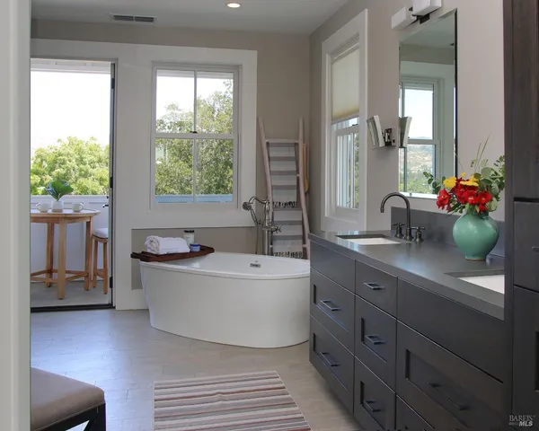 a spacious bathroom with a double vanity sink mirror and a bathtub