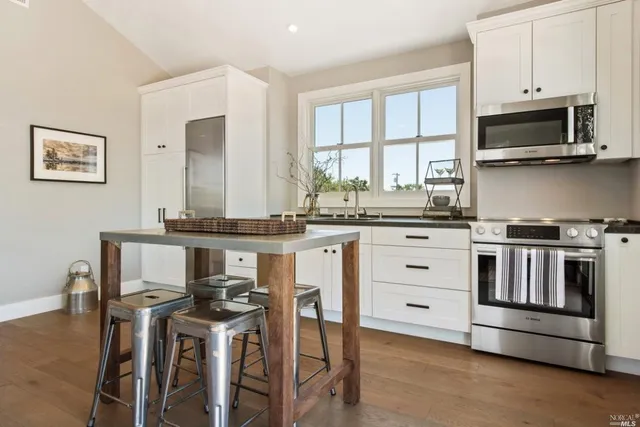 a kitchen with stainless steel appliances a stove top oven and a refrigerator