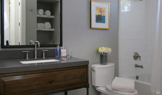 a bathroom with a toilet a sink and mirror