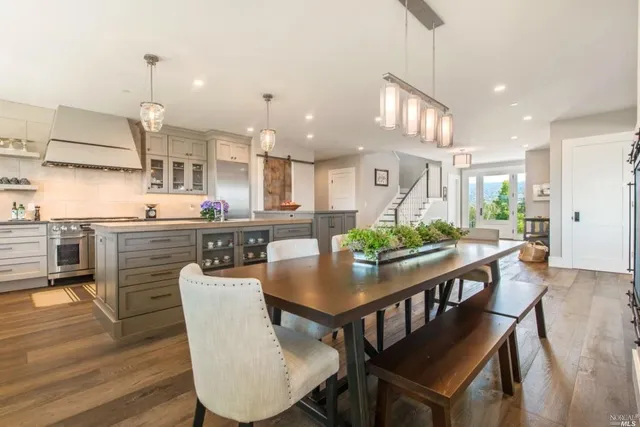 a dining room with stainless steel appliances kitchen island a table and chairs
