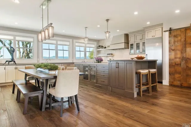 a kitchen with a table chairs refrigerator and cabinets