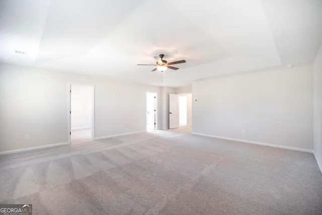 a view of an empty room with a ceiling fan