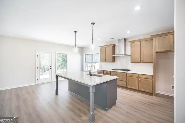 a kitchen with stainless steel appliances granite countertop a sink stove and wooden floor