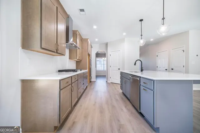 a kitchen with kitchen island granite countertop a sink a counter top stainless steel appliances and cabinets
