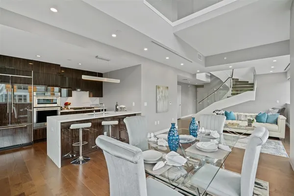 a kitchen with stainless steel appliances kitchen island granite countertop a table chairs stove and cabinets