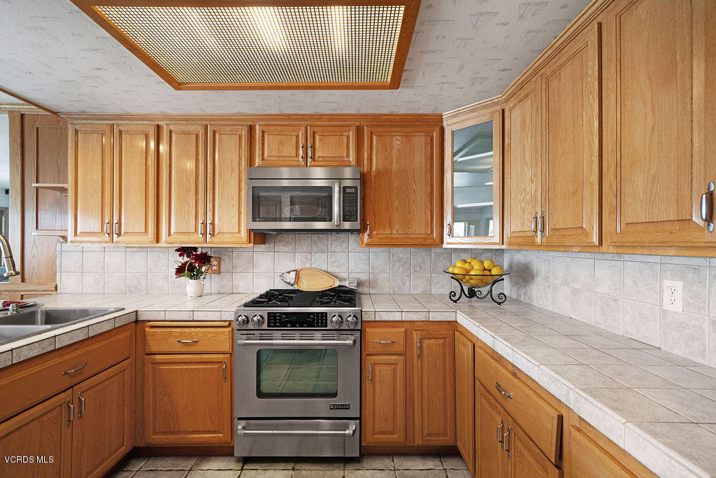 2260 Harbor Boulevard Oxnard, CA 93035 - Photo 17 of 28 a kitchen with a sink a window stainless steel appliances and cabinets