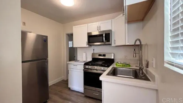 a kitchen with a refrigerator stove and white cabinets