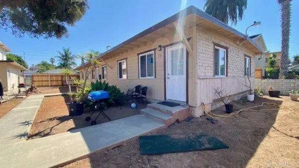 a view of a house with backyard and sitting area