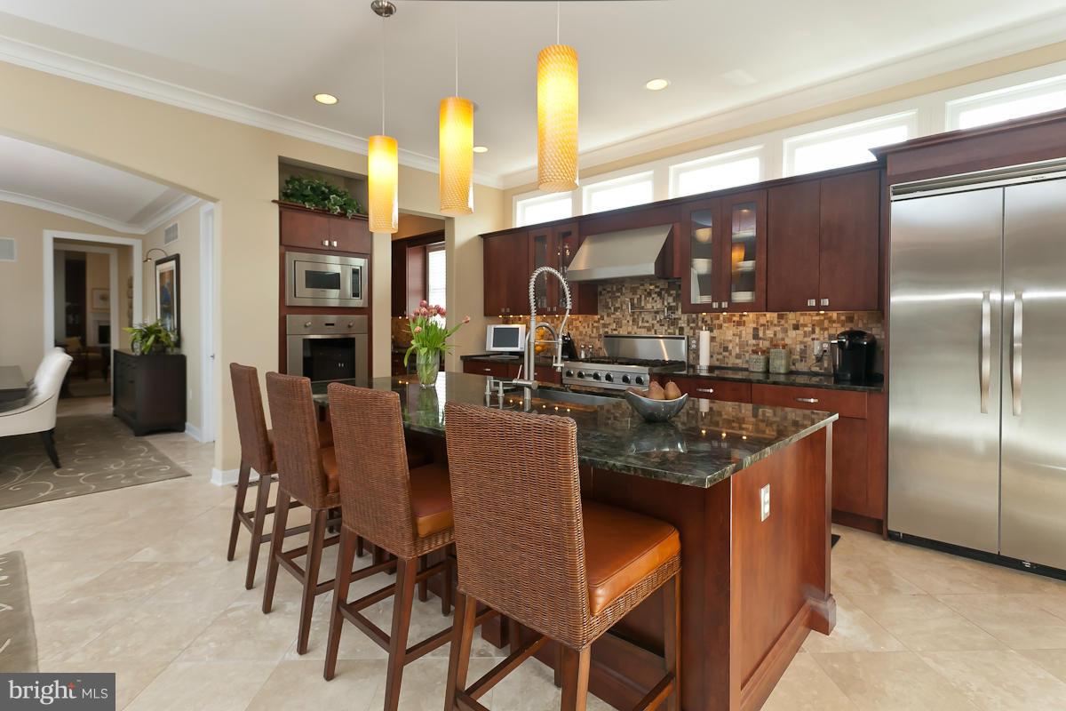 1712 Wilson Point Road Baltimore, MD 21220 - Photo 11 of 30 a kitchen with stainless steel appliances granite countertop a table chairs and a refrigerator