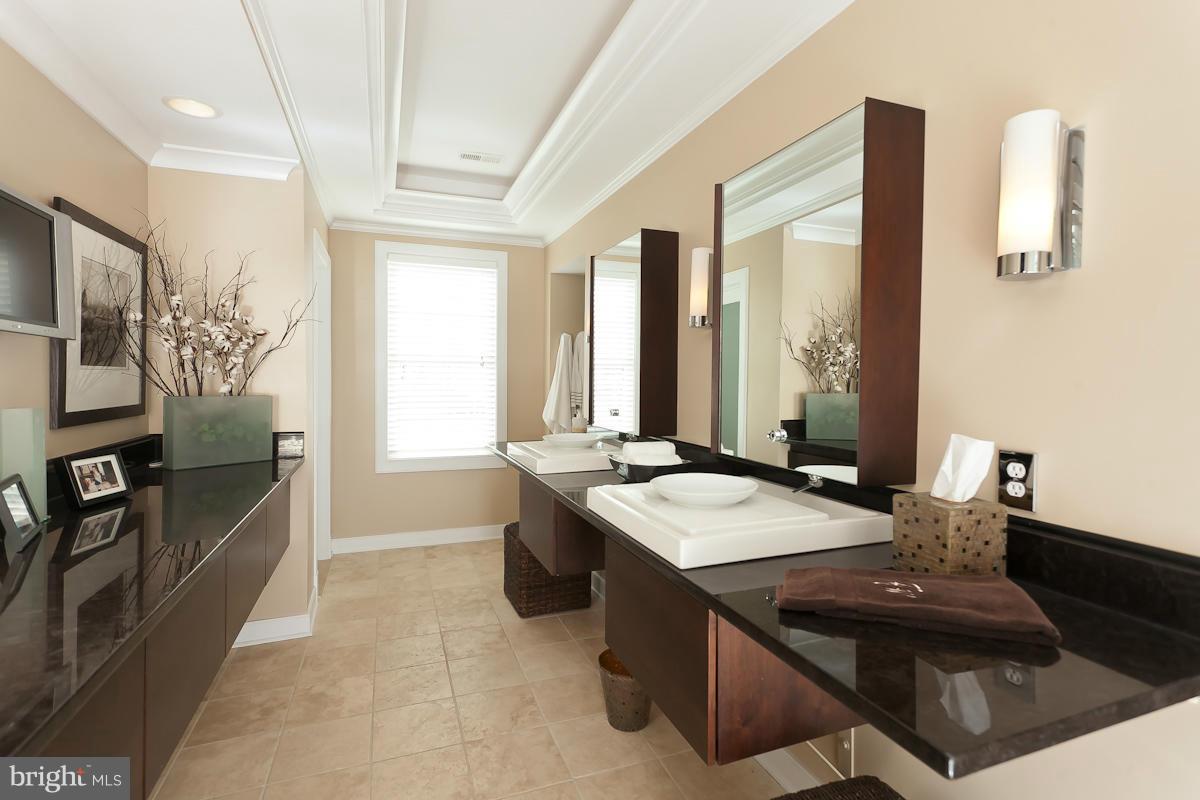 1712 Wilson Point Road Baltimore, MD 21220 - Photo 18 of 30 a bathroom with a granite countertop sink a large mirror and a bathtub