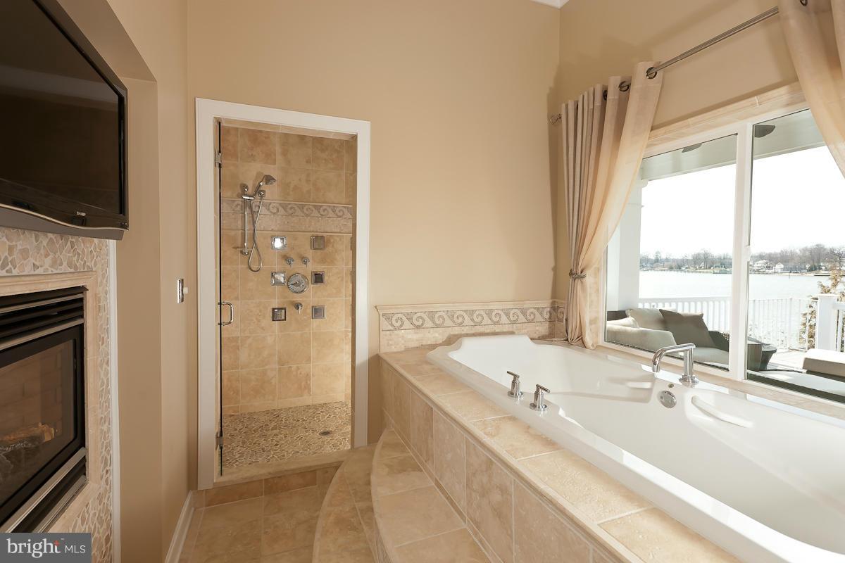 1712 Wilson Point Road Baltimore, MD 21220 - Photo 19 of 30 a bathroom with a tub a sink and a large mirror
