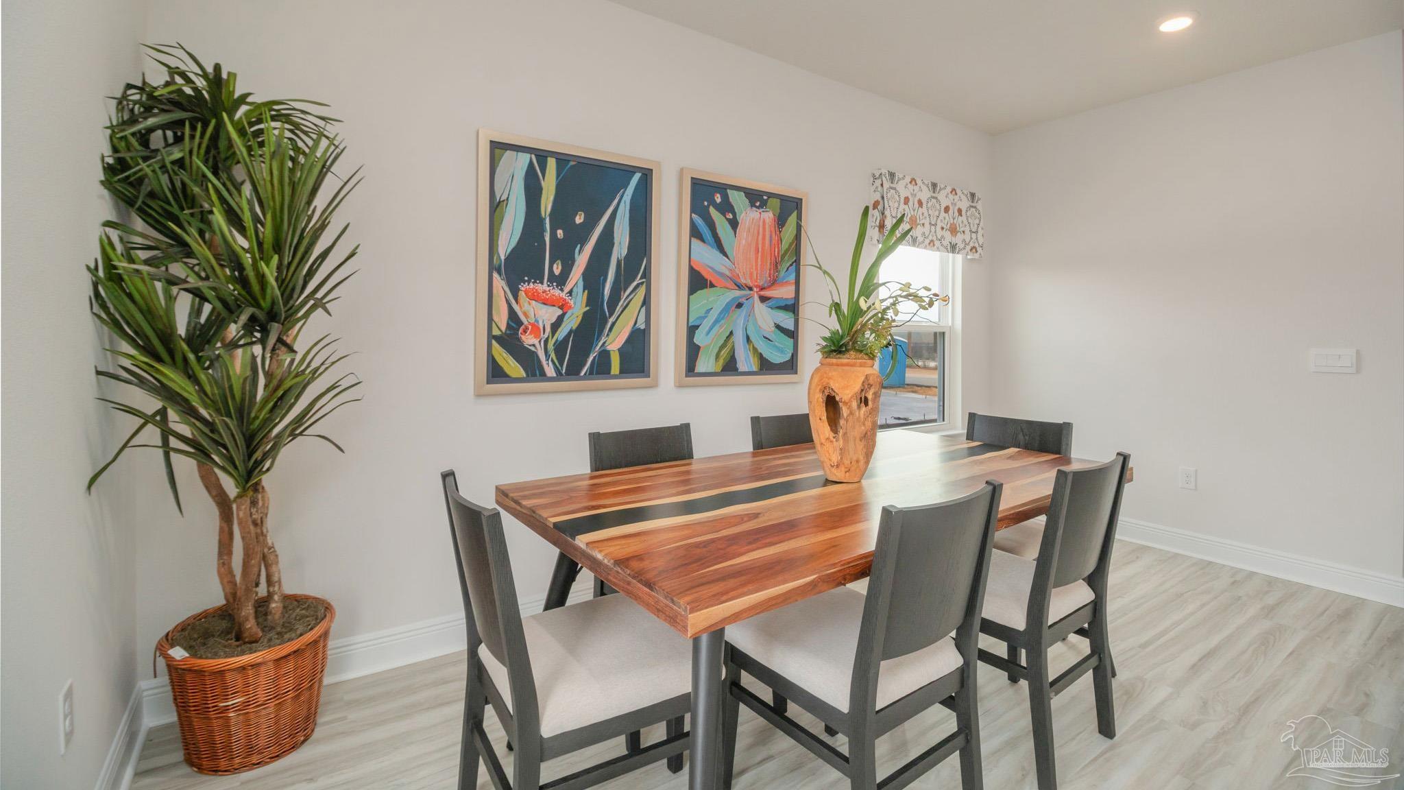 8717 Bluebell Street Milton, FL 32583 - Photo 12 of 30 a view of a dining room with furniture and wooden floor