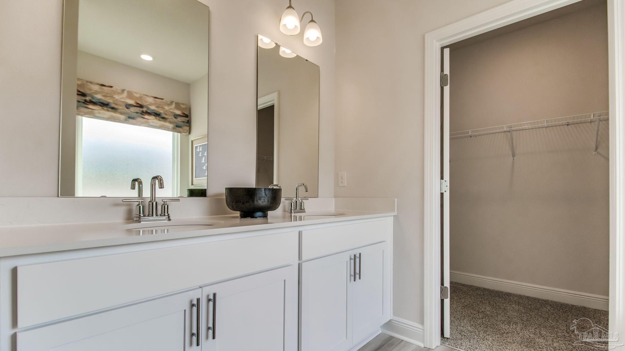 8717 Bluebell Street Milton, FL 32583 - Photo 17 of 30 a bathroom with a double vanity sink and a mirror