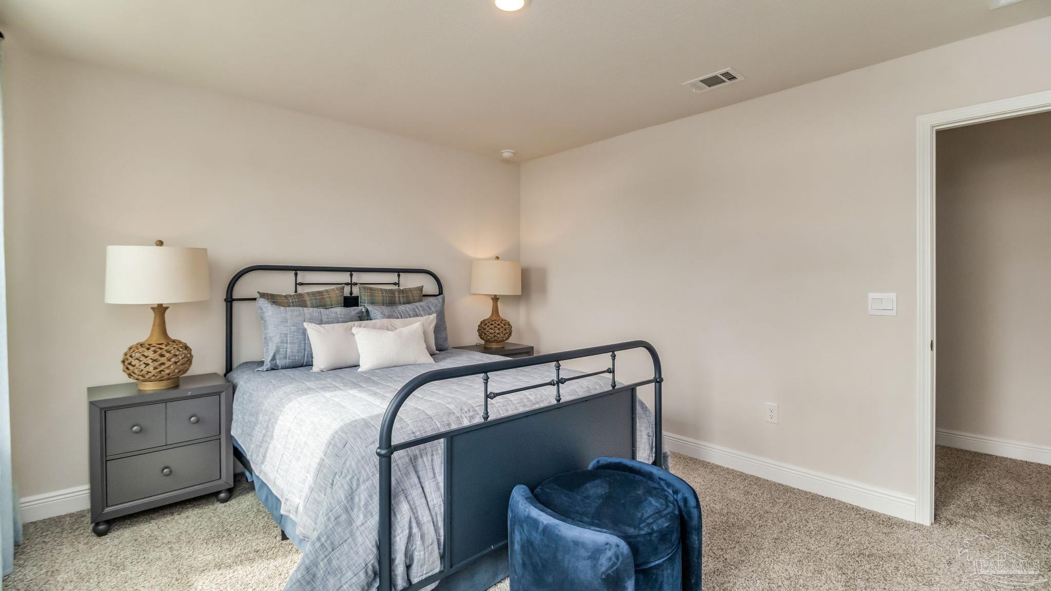 8717 Bluebell Street Milton, FL 32583 - Photo 26 of 30 a bedroom with a bed a lamp and mirror
