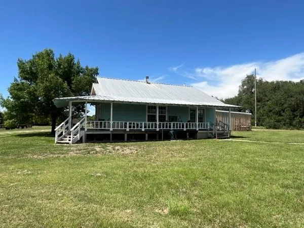 a view of a house with a yard and sitting area