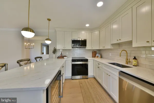 a kitchen with stainless steel appliances granite countertop a sink a stove top oven a counter space and cabinets