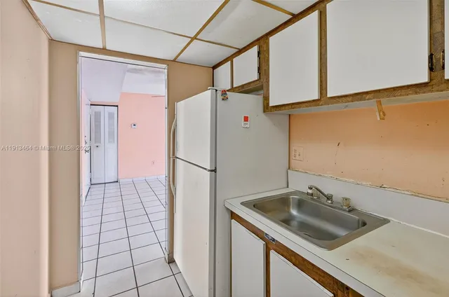 a kitchen with a sink a counter top space and stainless steel appliances