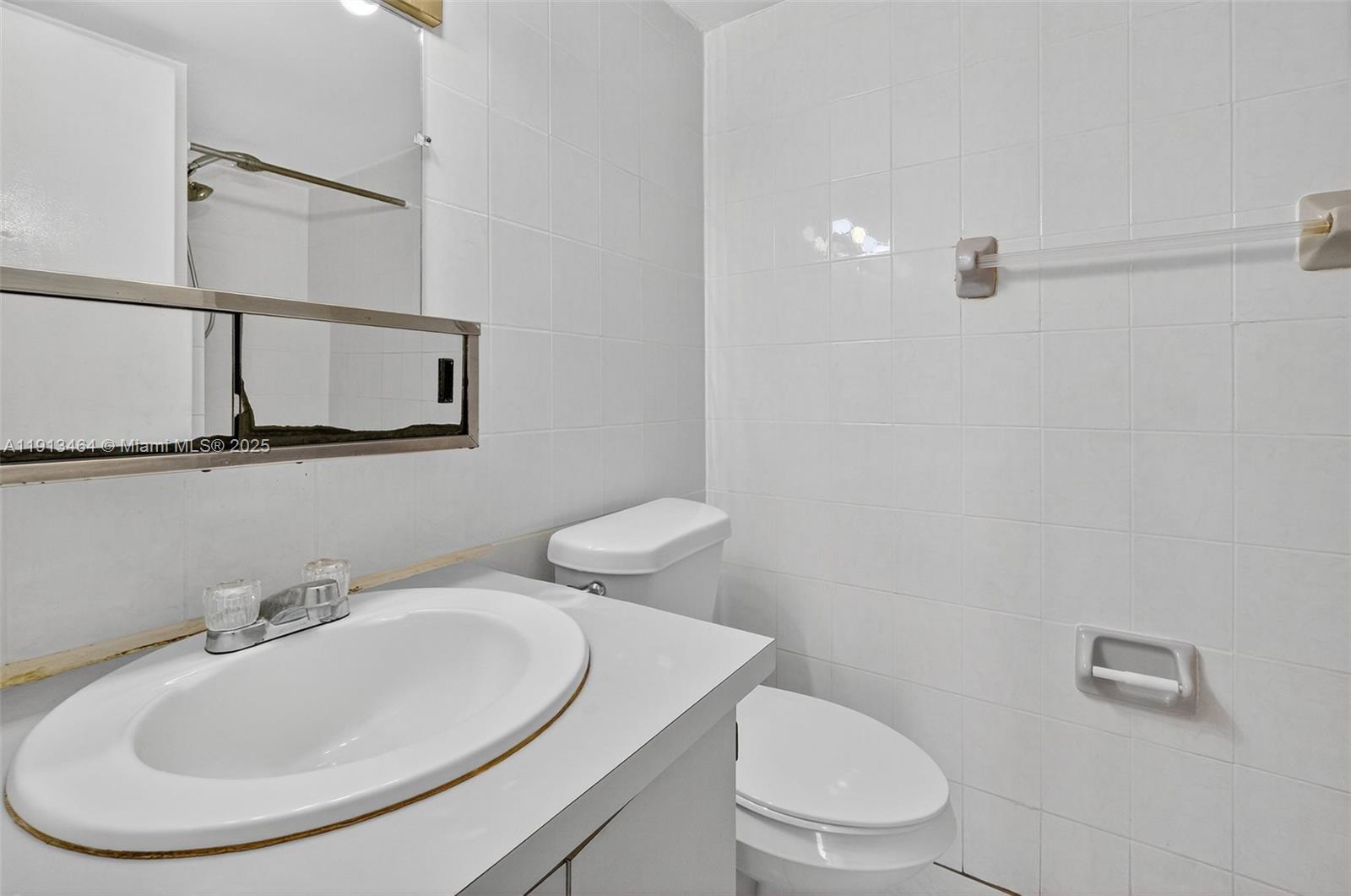 4841 Northwest 7th Street, Unit 3094 Miami, FL 33126 - Photo 22 of 33 a bathroom with a sink a toilet and mirror