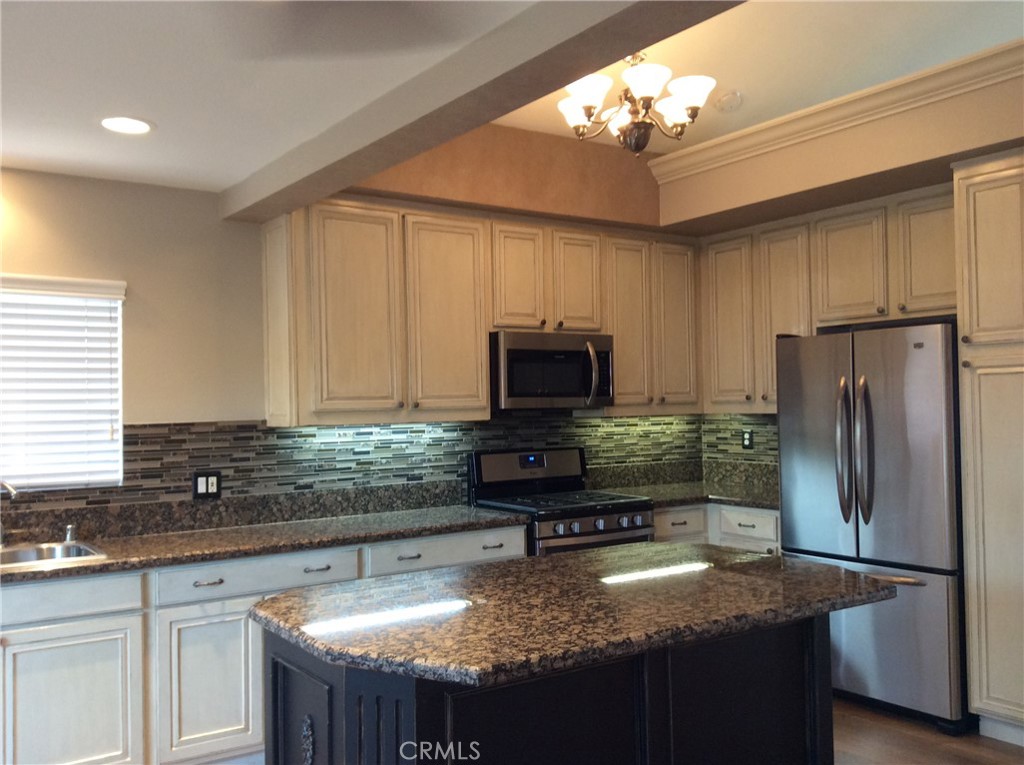 7 Mejorana Rancho Santa Margarita, CA 92688 - Photo 5 of 44 a kitchen with kitchen island granite countertop a sink refrigerator and microwave