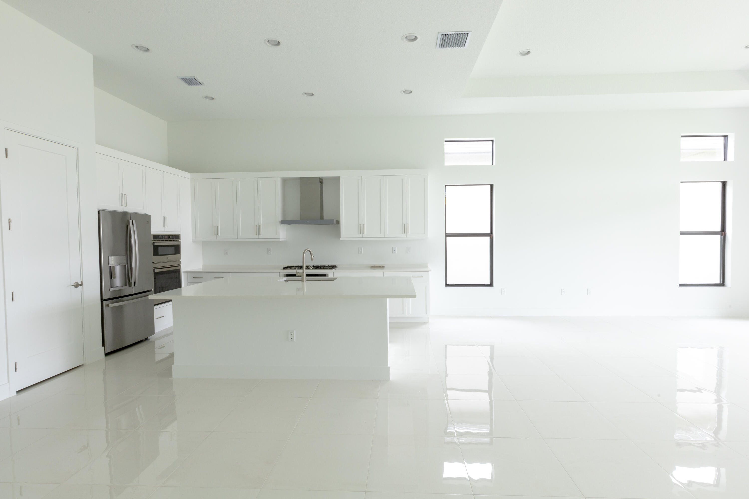 8252 Crystal Downs Avenue Boca Raton, FL 33434 - Photo 8 of 49 a large white kitchen with cabinets appliances a sink and a window