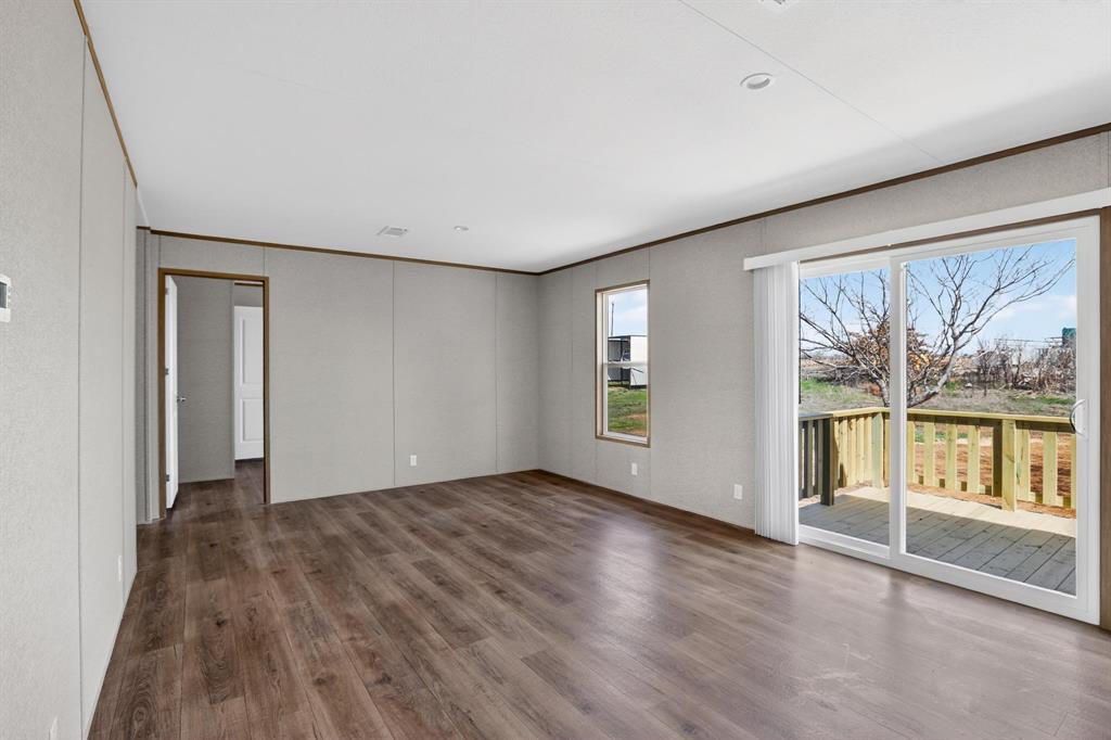 206 Rhett Court Aurora, TX 76078 - Photo 11 of 40 a view of an empty room with a window and wooden floor