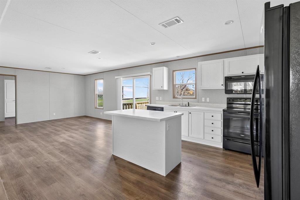 206 Rhett Court Aurora, TX 76078 - Photo 12 of 40 a kitchen with stainless steel appliances a sink cabinets and wooden floor