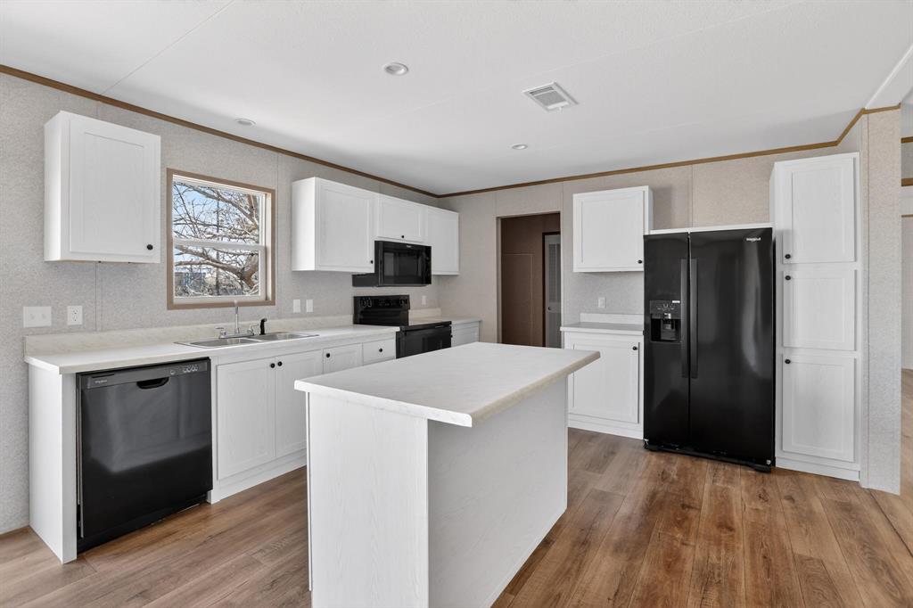 206 Rhett Court Aurora, TX 76078 - Photo 15 of 40 a kitchen with white cabinets and stainless steel appliances
