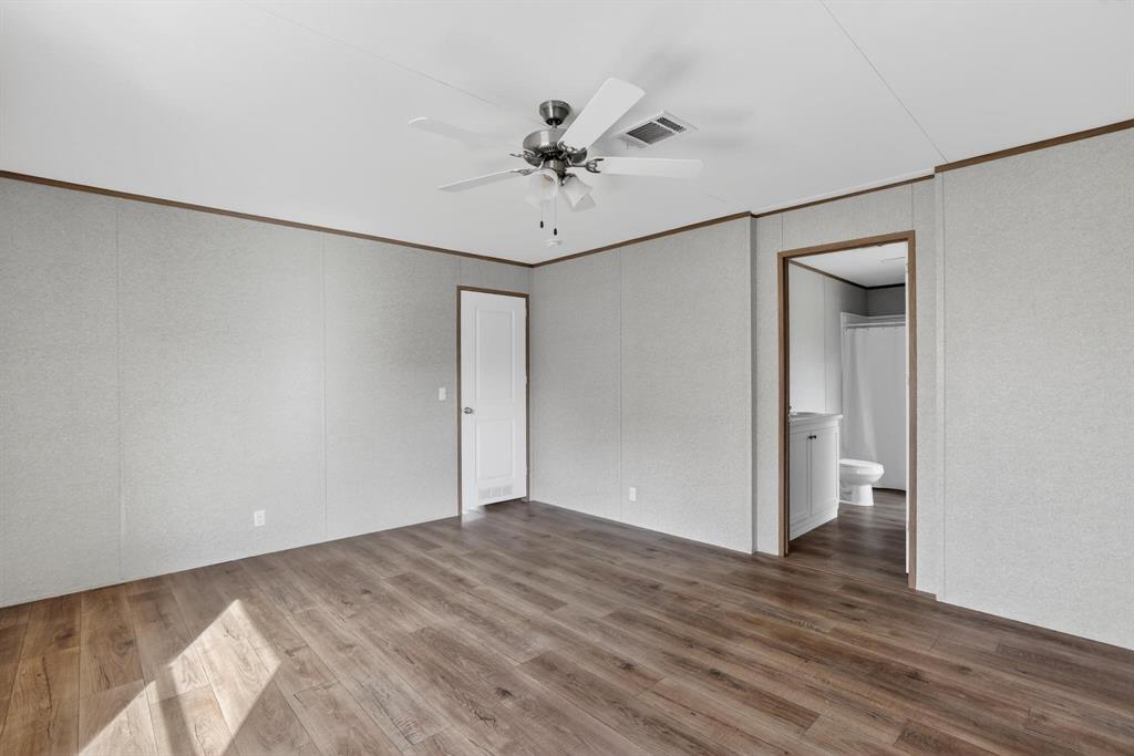 206 Rhett Court Aurora, TX 76078 - Photo 19 of 40 a view of an empty room with wooden floor and a ceiling fan