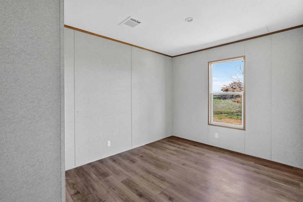 206 Rhett Court Aurora, TX 76078 - Photo 23 of 40 a view of an empty room with wooden floor and a window