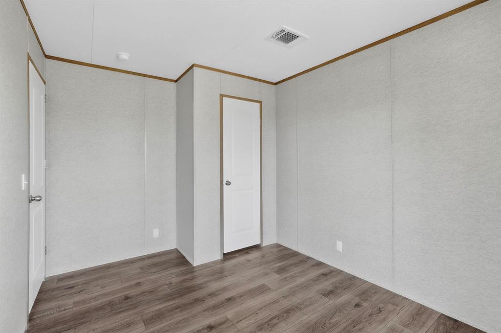 206 Rhett Court Aurora, TX 76078 - Photo 24 of 40 a view of an empty room with wooden floor and a window