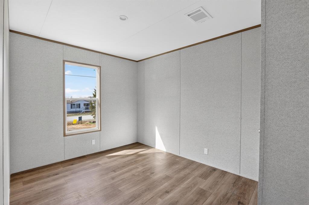 206 Rhett Court Aurora, TX 76078 - Photo 26 of 40 an empty room with wooden floor and windows
