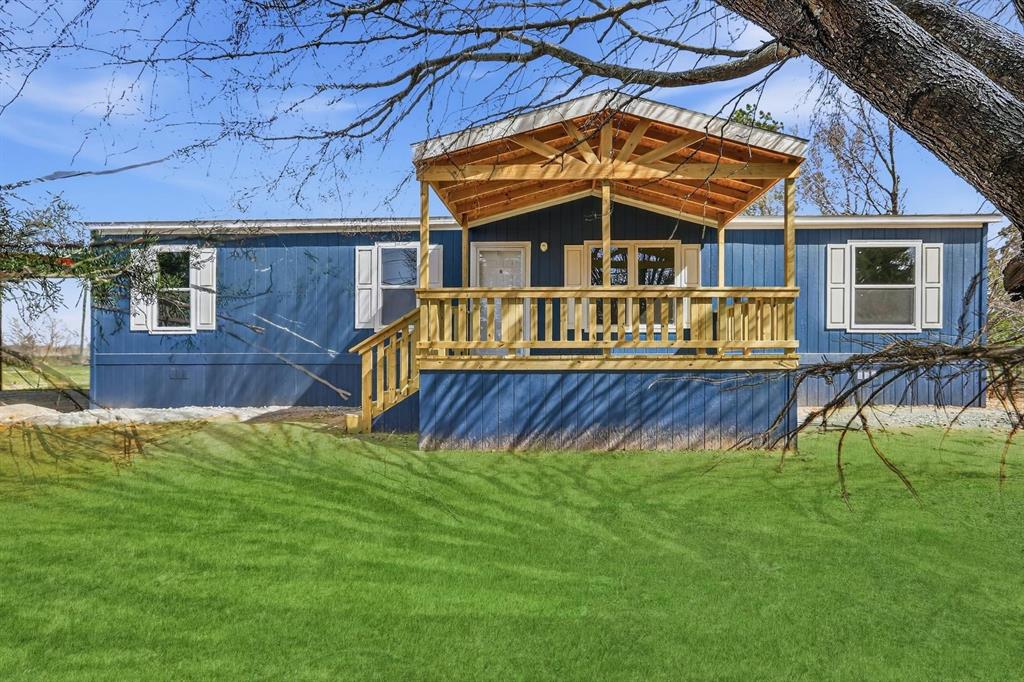 206 Rhett Court Aurora, TX 76078 - Photo 3 of 40 a view of a house with a yard deck and a small yard
