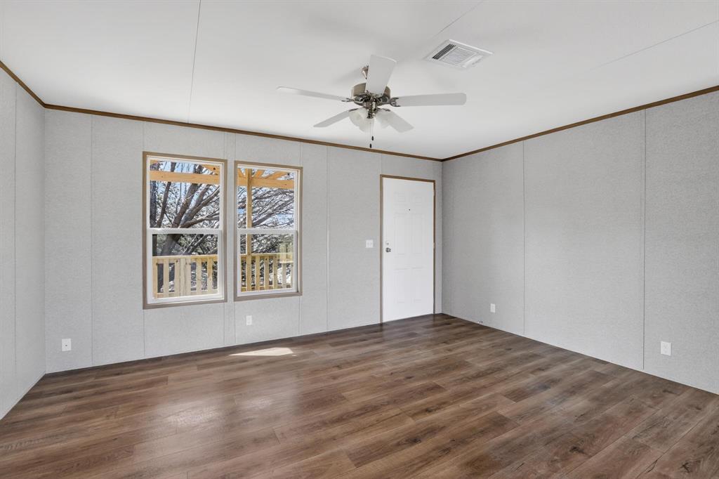 206 Rhett Court Aurora, TX 76078 - Photo 6 of 40 an empty room with windows and fan
