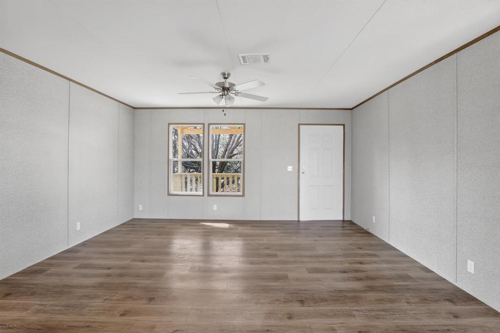 206 Rhett Court Aurora, TX 76078 - Photo 7 of 40 a view of an empty room with a window and wooden floor
