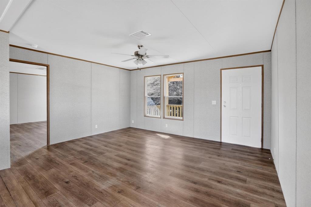 206 Rhett Court Aurora, TX 76078 - Photo 8 of 40 a view of an empty room with window and wooden floor