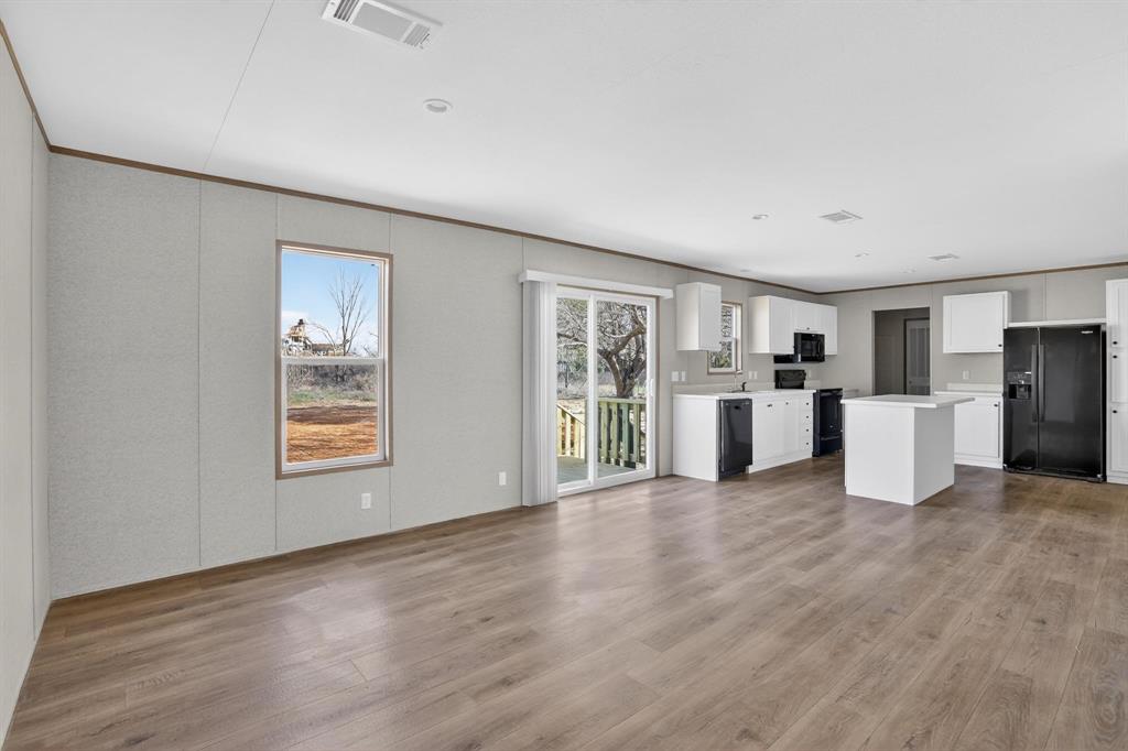 206 Rhett Court Aurora, TX 76078 - Photo 10 of 40 a view of a kitchen with a sink wooden floor and a refrigerator